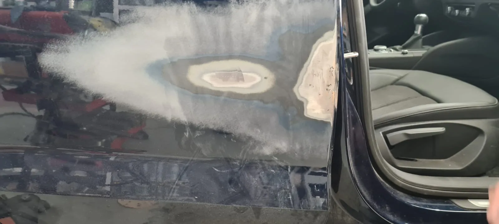 Retoque de pintura en una puerta en el taller de SIC R. Andía
